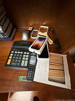 Group shot showing calculator, iPhone SE box, Nokia flip phone and colored pencils