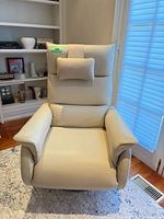 Front view of cream leather power recliner with headrest pillow