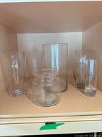 All six clear glass vases on shelf