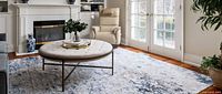 Rug displayed in living room under round coffee table
