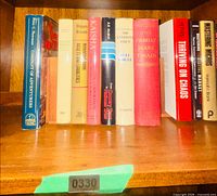 All nine hardcover books standing on shelf showing spines
