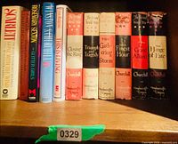 Shelf view of all 11 books showing spines and dust jackets
