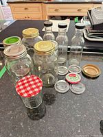 Group view of Mason jars, bottles, jam jar, and loose lids