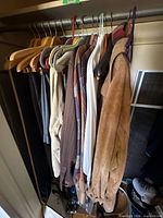 Clothing on closet rod showing variety of shirts and jackets