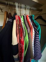 Row of hanging shirts in various colors and patterns on hangers