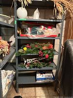 Full view of grey metal rack with five shelves, contents present for scale only