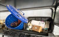Blue bin with extension cords and lid visible