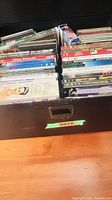 Drawer containing rows of DVDs and CDs