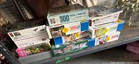 Stack of boxed puzzles showing brands and piece counts