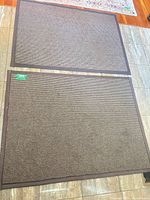 Two matching brown entry mats on floor