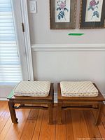 Two wooden stools side by side with cushions on top