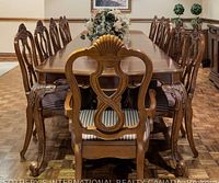 dining table surrounded by twelve carved wooden chairs