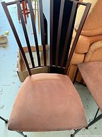 Front view of chair showing metal slat back and upholstered seat