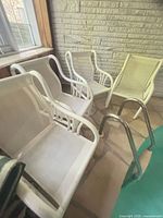 Group of four white patio chairs