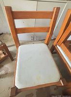 Wood dining chair front view showing ladder back and stained seat cushion
