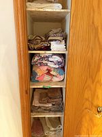 Full view of closet shelves with quilts and towels