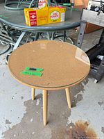 Full view of round side table with glass top and three legs