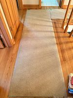 top view of full beige carpet runner laid on hardwood floor