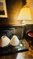 Group view: floor lamp, candlestick table lamp, globe-base table lamp with shades