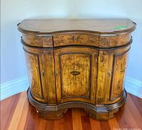 Front view of Hooker Furniture Seven Seas sideboard showing painted motifs and curved front