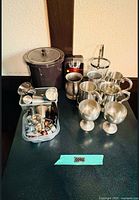 Overview showing both ice buckets, stainless drinkware, plastic tub of bar tools