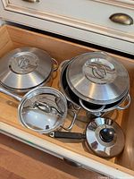 drawer view showing all pots, lids and saucepan