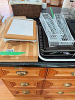 stack of cutting boards, wire baskets and metal trays on countertop