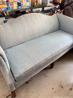 overview of blue upholstered sofa showing fabric, legs, and cushion