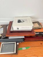 Stack of assorted frames with boxed photo album on top