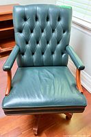 Front view of green leather tufted executive chair