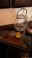 overview showing lantern, pipe holder on No Smoking board, glass globe and matchbox