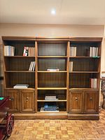 Front view of three-section wall unit with shelves and lower cabinets