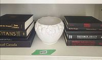 Bowl centered between two stacks of books on shelf