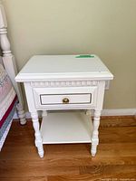 Full view of white nightstand beside bed