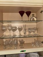 Cabinet showing multiple types of stemware and decanter