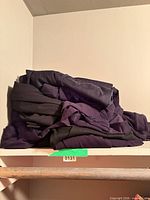 Stack of folded dark women’s pants on shelf