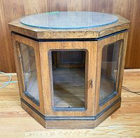 Front view of hexagonal wood end table with glass top and panels