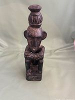 Front view of carved wooden seated figure statue