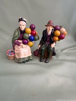 Both ceramic balloon seller figurines front view
