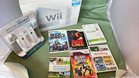 Grouped view of boxed Wii console, six game cases and Nyko charger