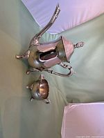 Teapot beside creamer showing overall form and finish
