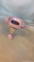 Full view of vase showing pedestal base, flared engraved rim and tarnish