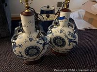 Two blue and white ceramic lamp bases with oriental motif, wood bases, brass hardware