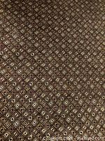 Close-up of carpet pattern highlighting brown, black, tan diamond design