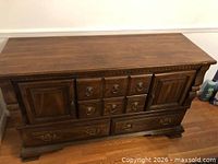 Front view of brown wood buffet sideboard showing drawers, doors, hardware