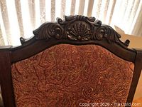 Close-up of carved crest and upholstery pattern