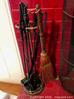 Complete fireplace tool set on stand next to fireplace