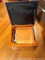 Hinged top open showing interior compartment and hardware
