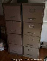 Two beige metal vertical 4-drawer file cabinets side by side