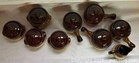 Top view of all eight lidded bowls and pitcher
